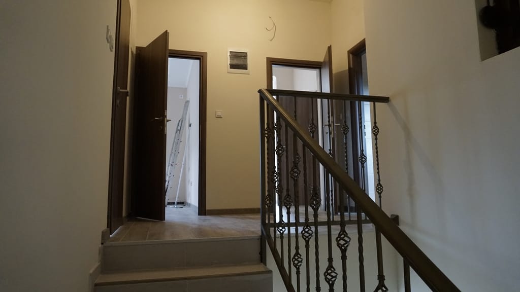 Interior of a villa in Igalo, Montenegro: staircase with wrought-iron railings and bright rooms with interior doors.