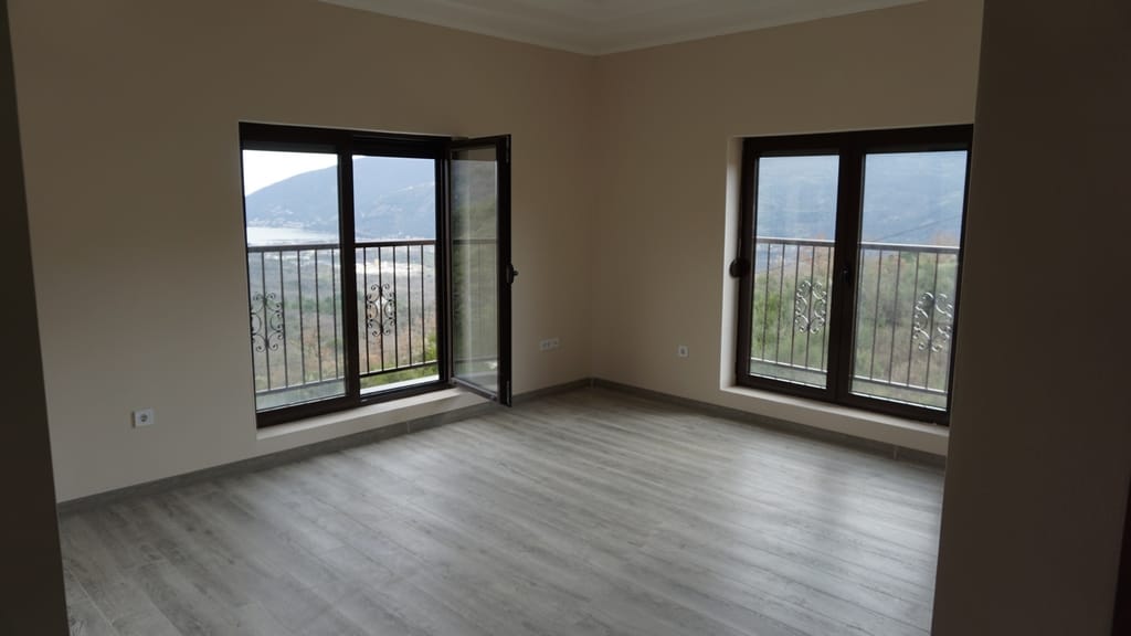 Bright living room with laminate flooring and panoramic views of the mountains and sea in a villa, Igalo, Montenegro.