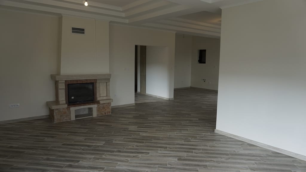 Spacious living room with a fireplace and wood-style finishes in a villa in Igalo, Herceg Novi, Montenegro.