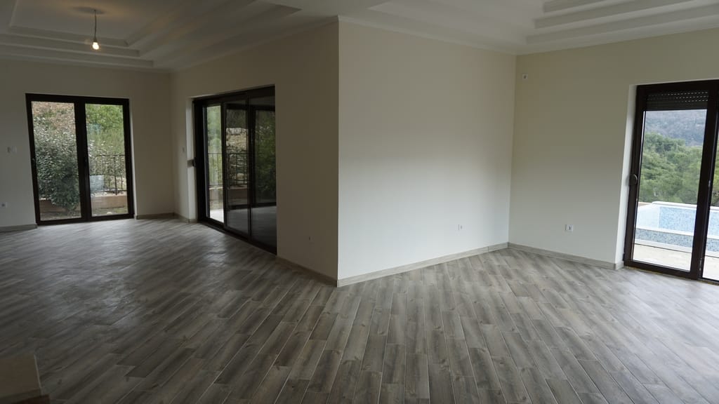 Spacious living room with panoramic windows and access to the pool in a villa in Igalo, Montenegro. Bright interior.