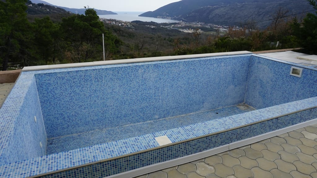 Empty pool with blue mosaic and panoramic view of the mountains and sea in Igalo, Herceg Novi, Montenegro.