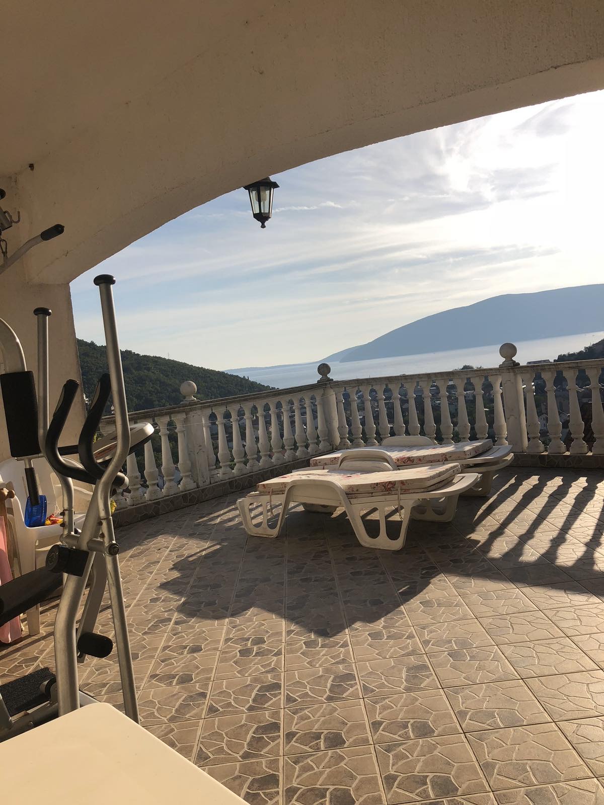 Terrace with sun loungers and exercise equipment at a mini-hotel, sea and mountain view, Herceg Novi, Montenegro.