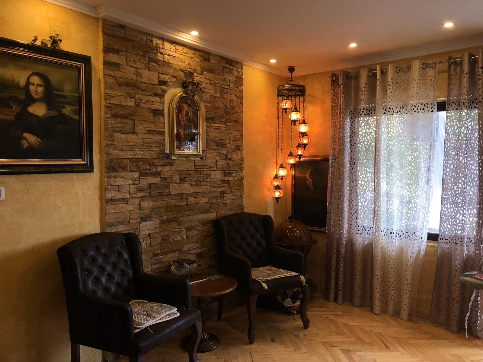 Living room in the Zelenika mini-hotel, Herceg Novi, Montenegro: leather armchairs, stone finishes, and oriental lamps.