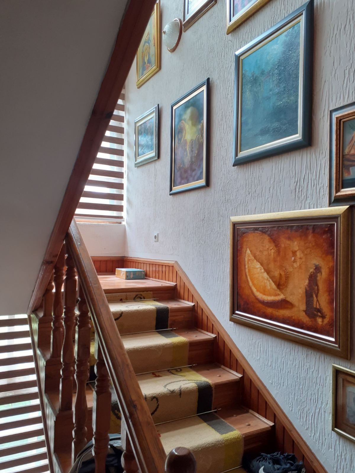 Wooden staircase with carpet and paintings on the walls in a mini-hotel, Zelenika, Herceg Novi, Montenegro.