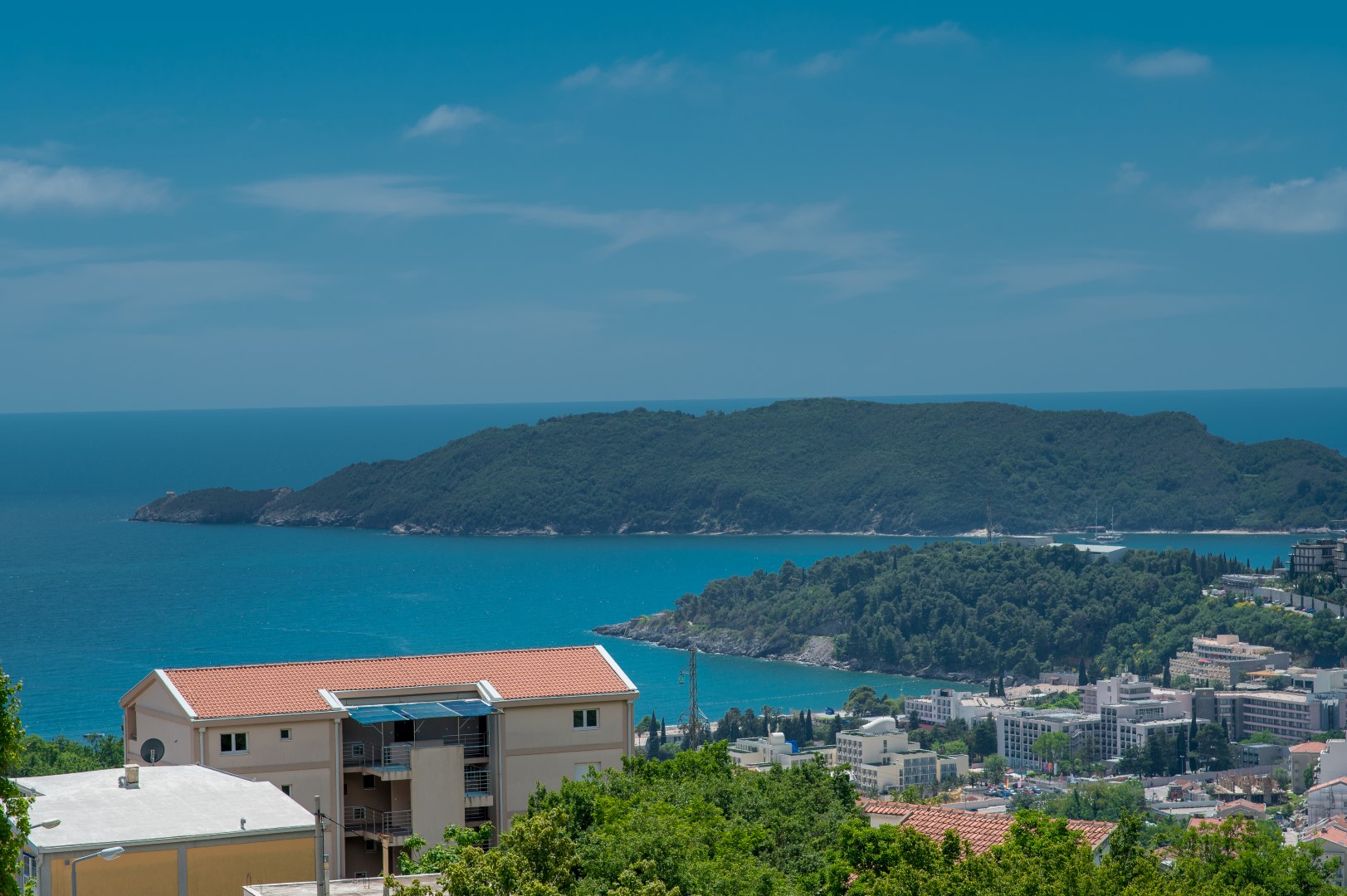 Panoramic view of the sea and St. Nicholas Island from a villa in Bečići, Montenegro: a residential building and resort landscape.