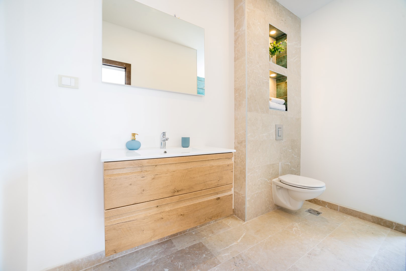 Modern bathroom with stone finishes and a wooden vanity in a villa in Bečići, Montenegro.