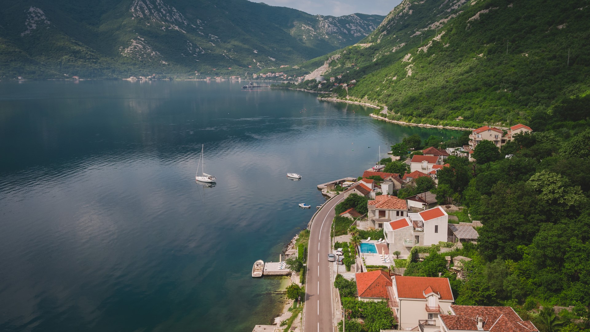 Aerial view of a villa in Strp, Montenegro: a coastal house with a pool, terrace, and panoramic views of the Bay of Kotor.