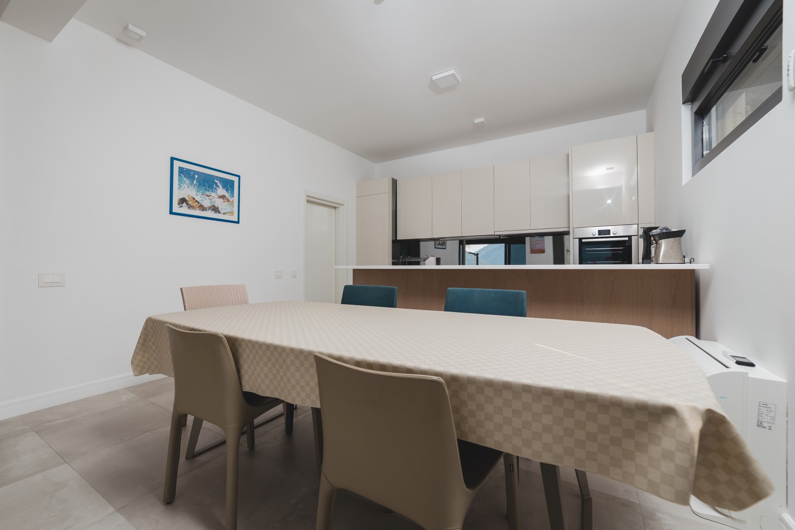 Modern kitchen-dining room in a villa in Strp, Montenegro: dining table, built-in cabinetry, and a bright interior.