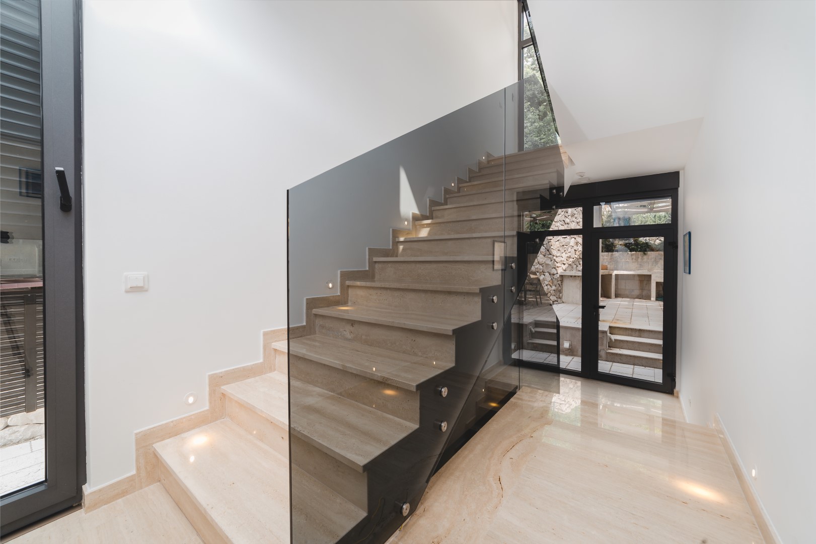 Modern stone staircase with glass railing in the interior of a villa in Strp, Montenegro.