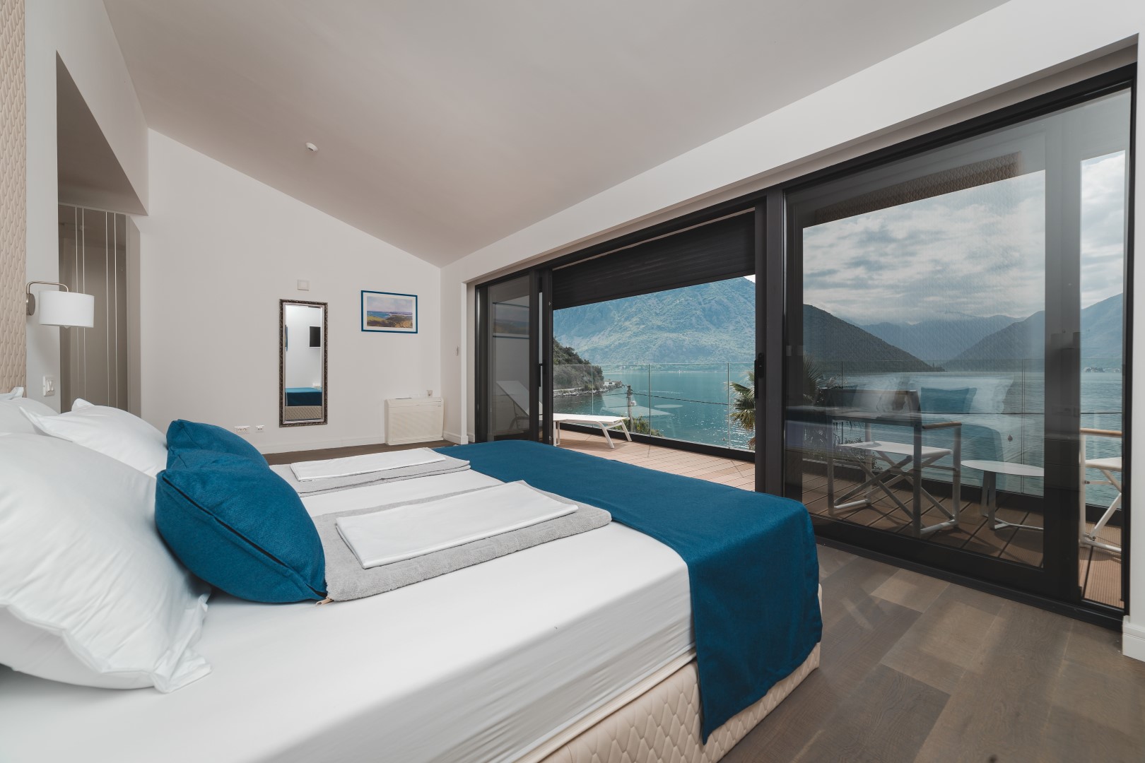 Bedroom in a villa in Strp, Montenegro: panoramic windows with sea and mountain views, terrace, and modern interior.