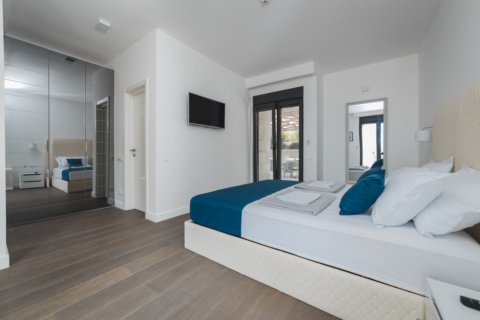 Modern bedroom with a double bed and mirrored wardrobe in a villa in Strp, Montenegro.