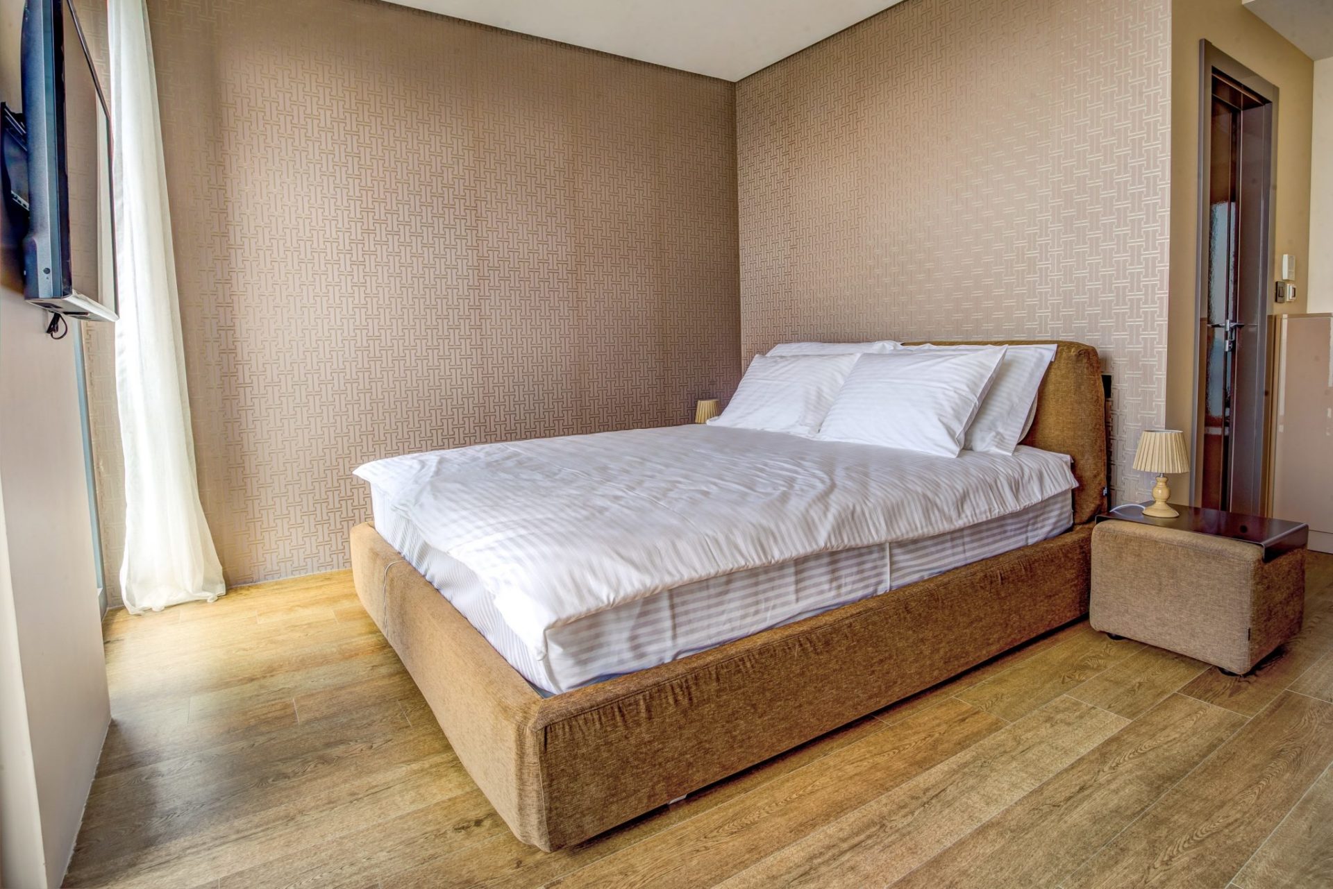 Cozy bedroom with a double bed and beige decor in a villa in Budva, Montenegro.