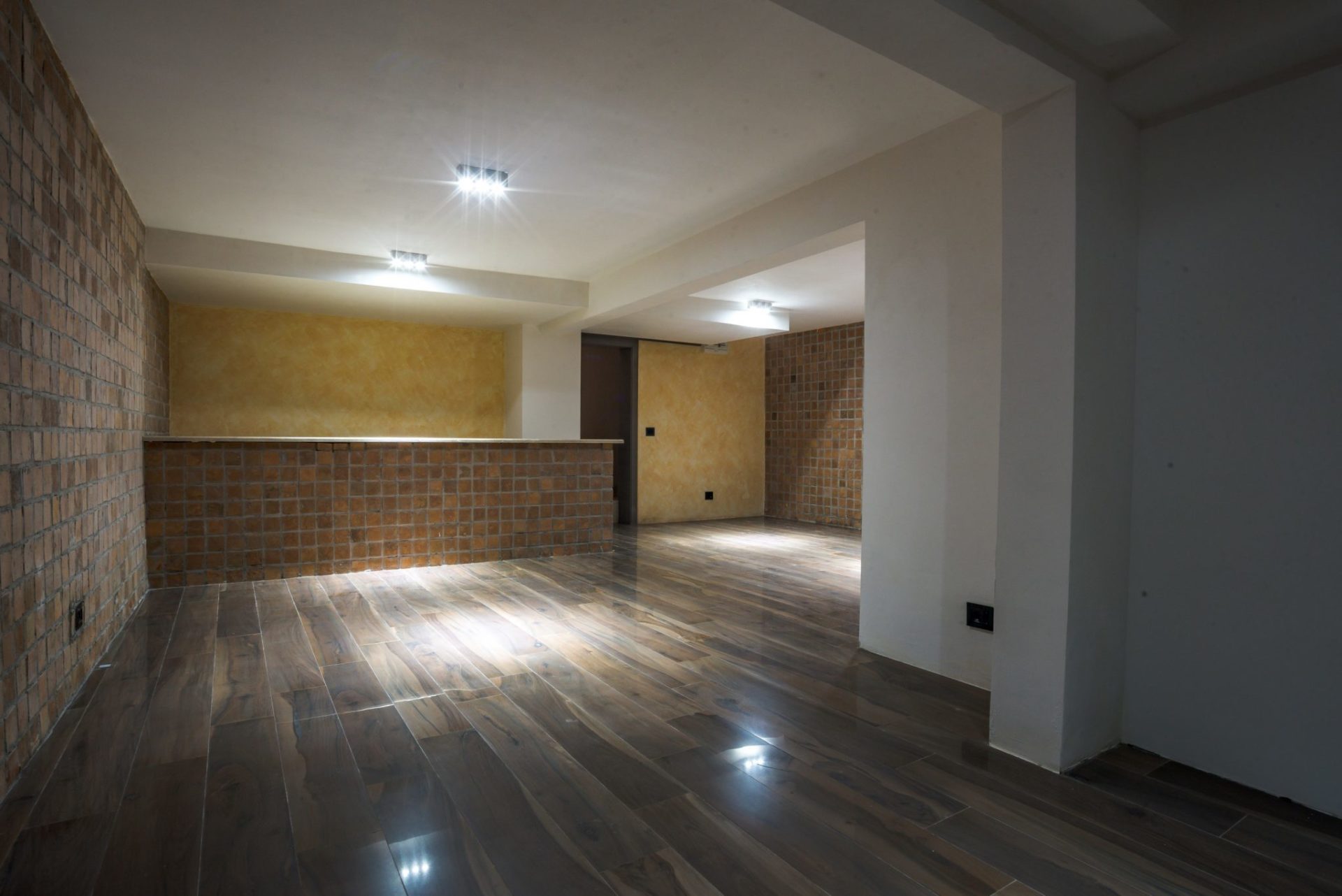 Living room with a bar counter, brick finishes, and wood-look tile in a villa in Budva, Montenegro.