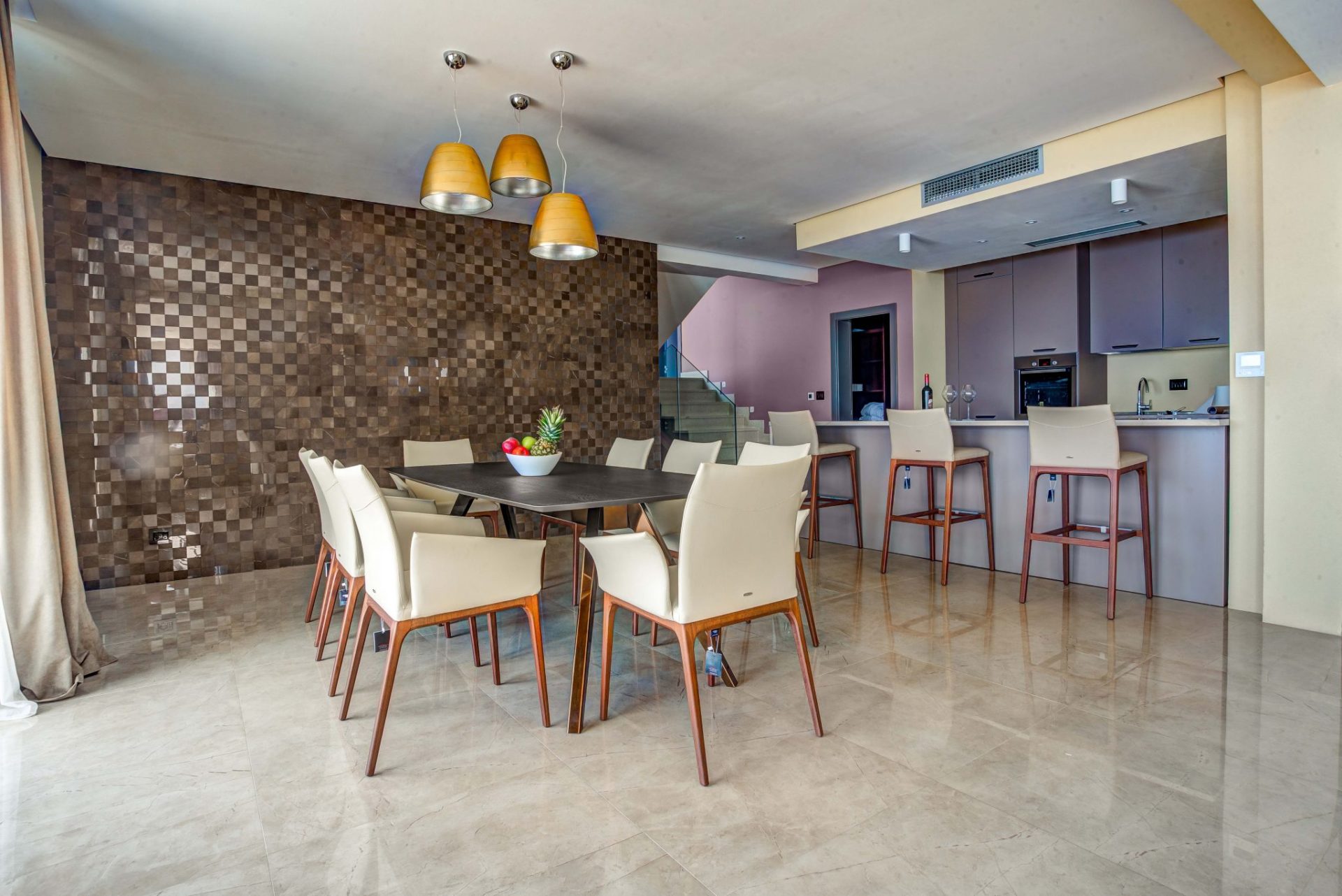 Modern living room with dining area and kitchen in a villa in Budva, Montenegro: stylish furniture and marble floor.