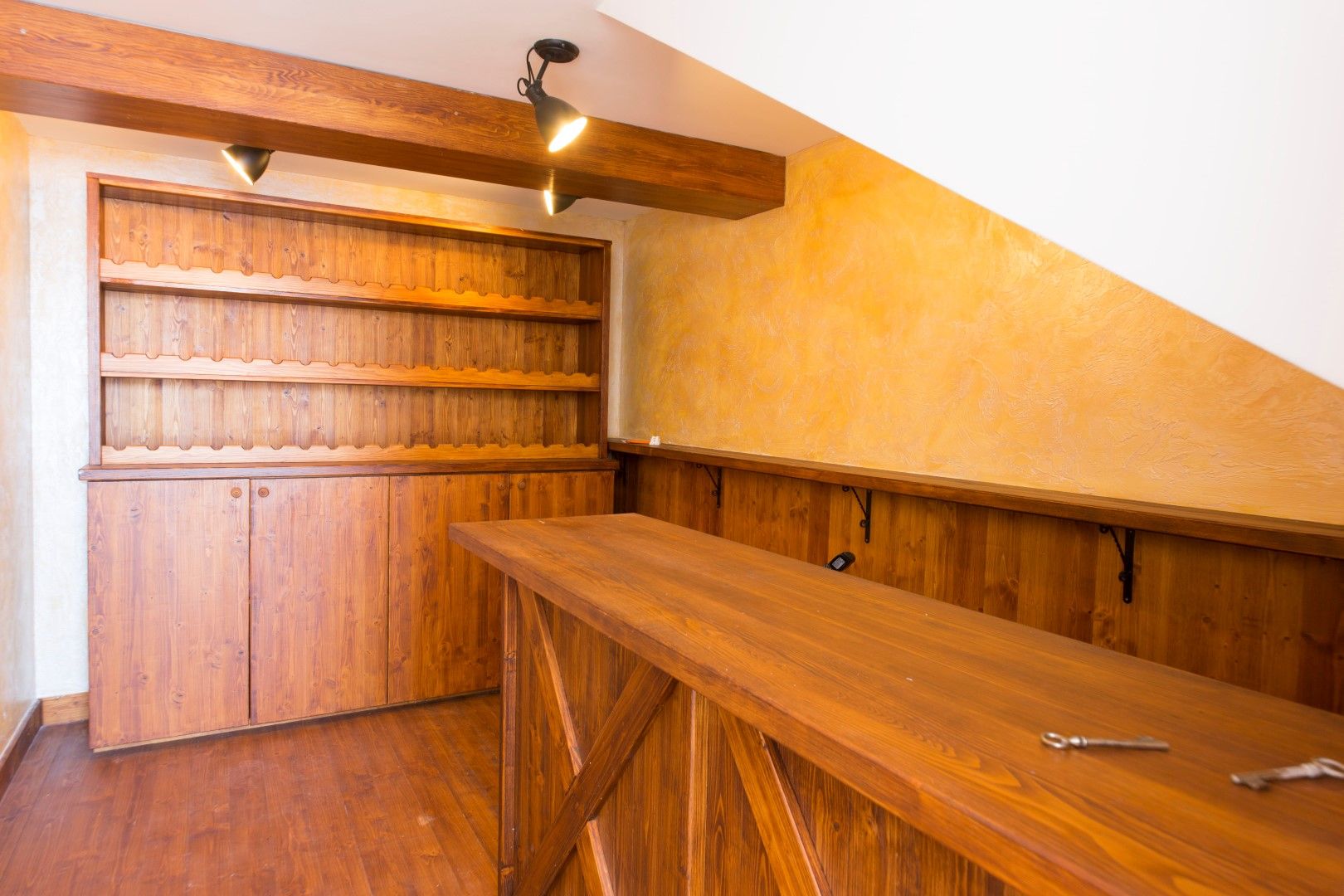 Wooden bar counter and wine rack in the interior of a villa in Krašići, Montenegro, with natural wood finishes.