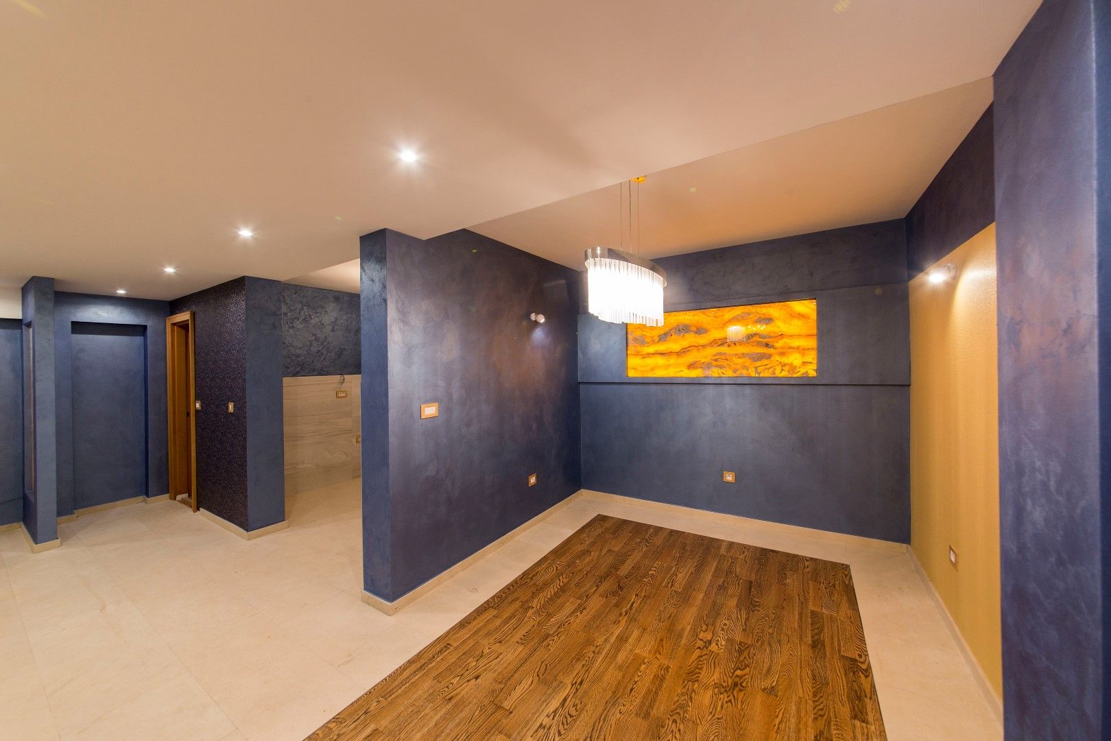 Living room with designer finishes and lighting in a villa in Krašići, Montenegro: parquet flooring, blue walls, and stylish decor.
