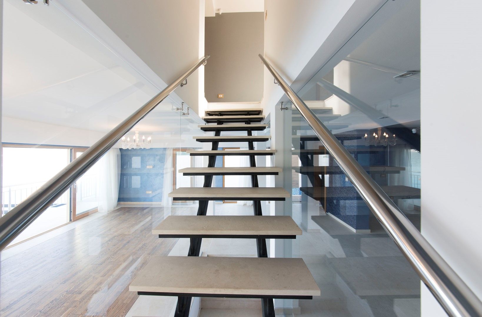 Modern staircase with stone steps and glass railing in a villa interior in Krašići, Montenegro.