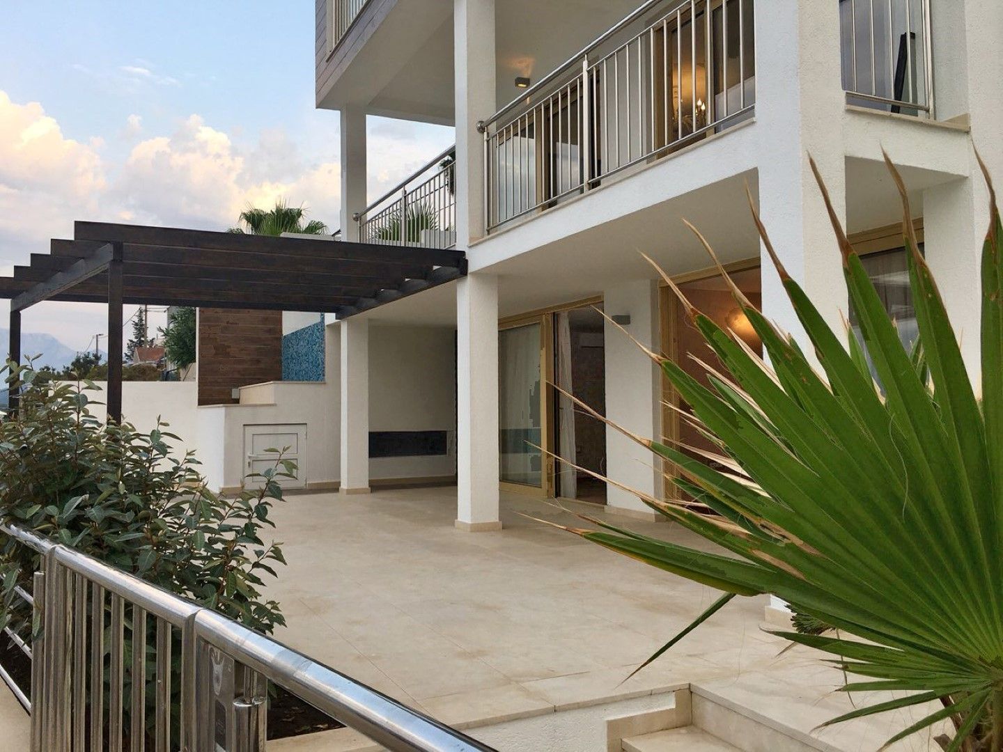 Modern villa in Krašići, Montenegro: spacious terrace with pergola, panoramic glazing, and a stylish facade.