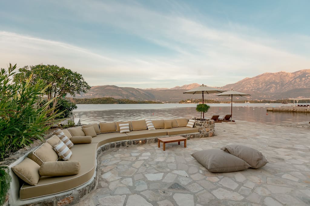 Villa terrace on the first line in Luštica, Montenegro: stone patio, soft seating, and panoramic sea view.