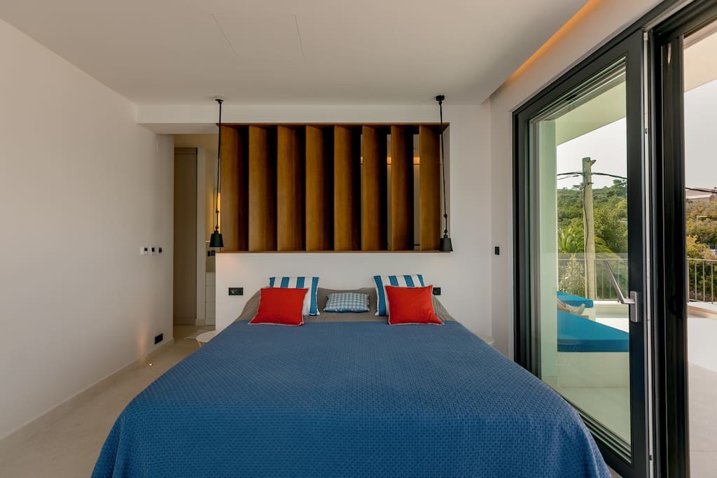 Modern bedroom with a double bed and access to the terrace in a villa in Luštica, Montenegro.