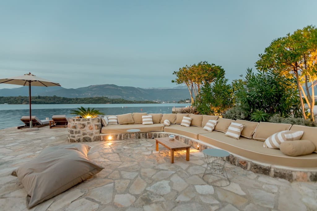 Villa terrace on the first line in Luštica, Montenegro: stone finish, a soft sofa, sea and mountain views.
