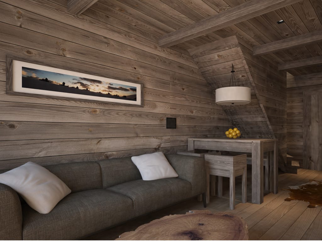 Living room interior in a hotel in Kolasin, Montenegro: wood finishes, gray sofa, solid wood table, and mountain style.