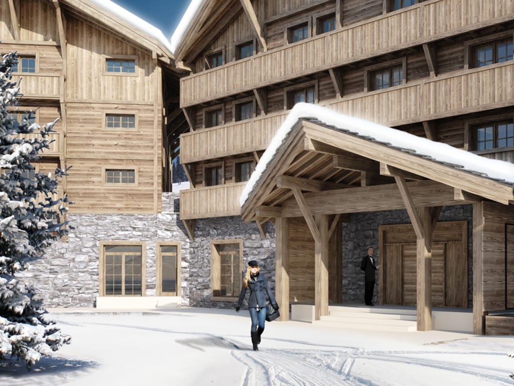 Facade of a mountain hotel made of wood and stone in Kolašin, Montenegro, with a snow-covered grounds and a chalet-style entrance.