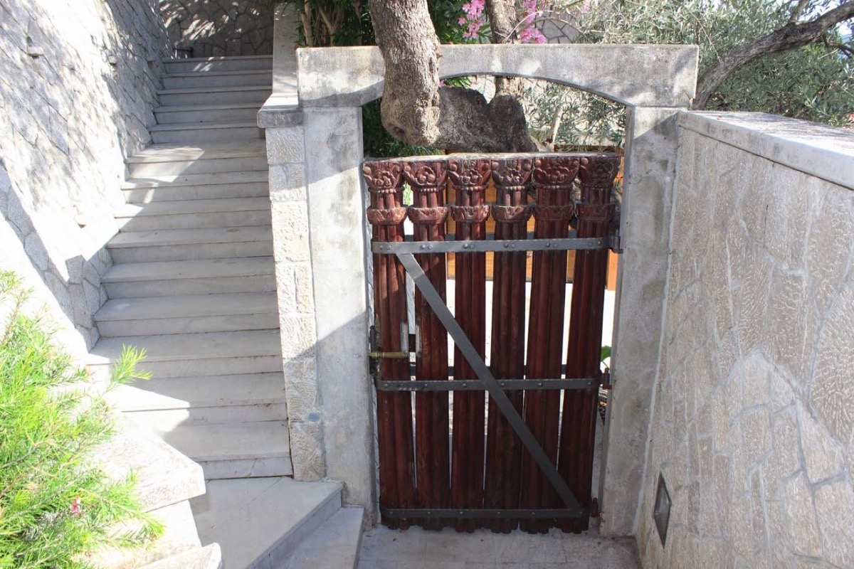 Decorative wooden gate and stone staircase at a villa in Budva, Montenegro.