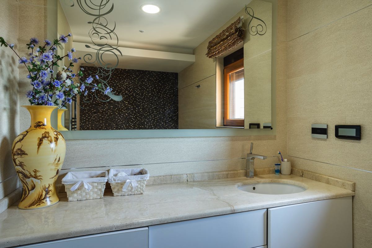 Modern bathroom with a marble countertop and mirror in a villa in Budva, Montenegro. Stylish bathroom interior.