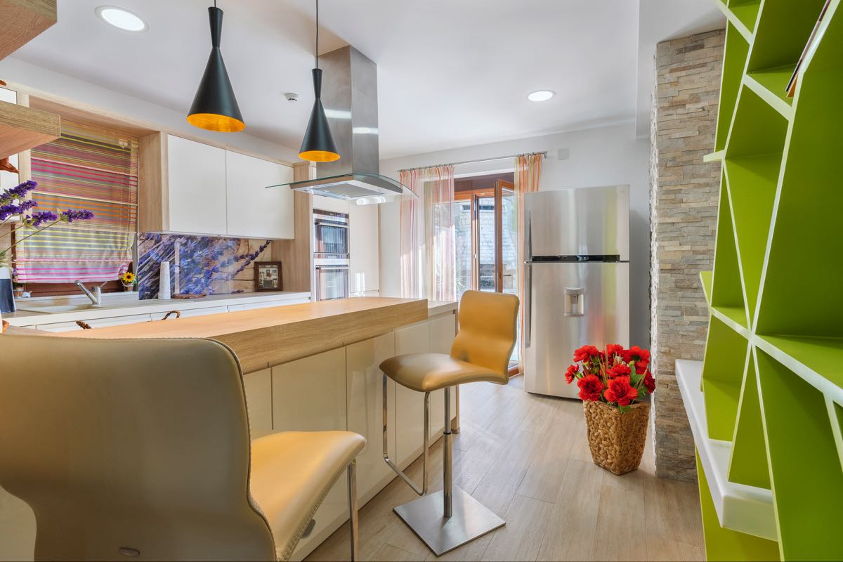 Modern kitchen with a bar counter and a bright shelving unit in a villa in Budva, Montenegro: stylish interior and decor.