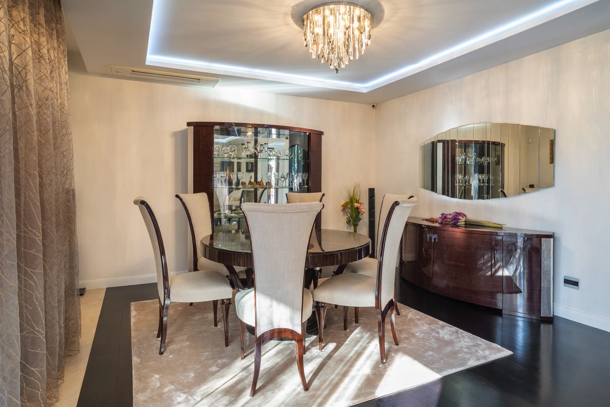 Luxurious dining area with dark furniture and a crystal chandelier in an exclusive villa in Budva, Montenegro.
