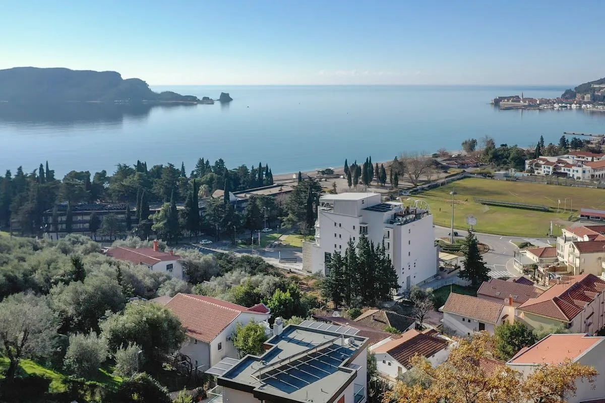 Panoramic view of the coastline, sea, and city rooftops from an elevated vantage point.