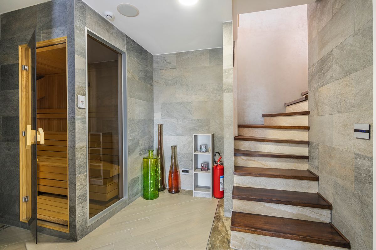 Modern sauna and wooden staircase in the interior of a villa in Budva, Montenegro, with stone finishes and stylish decor.