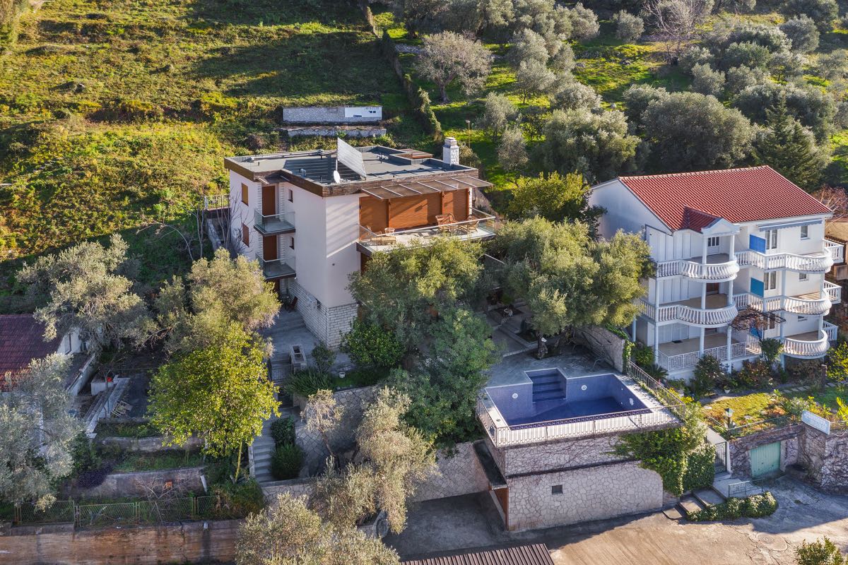 Villa in Budva, Montenegro: view of the house with terraces, an olive grove, and a private pool on a mountainside.