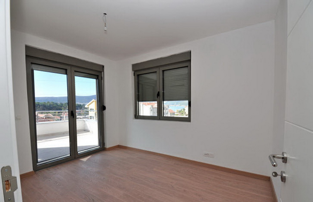 Bright bedroom with access to the terrace and sea view in a new residential complex in Tivat, Montenegro.