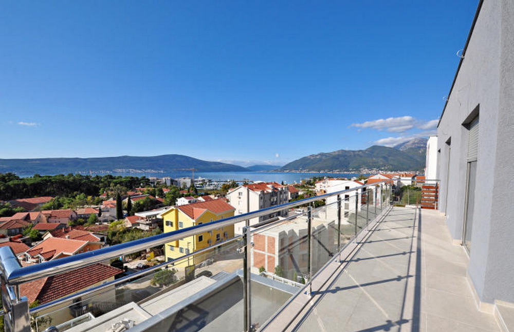 Spacious balcony with panoramic views of the sea and mountains in a residential complex, Tivat, Montenegro. Modern railing.