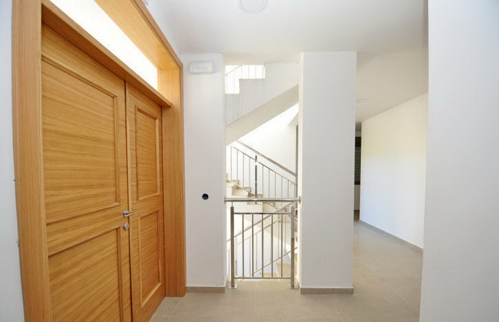 Modern lobby interior with wooden doors and staircase in a residential complex, Tivat, Montenegro