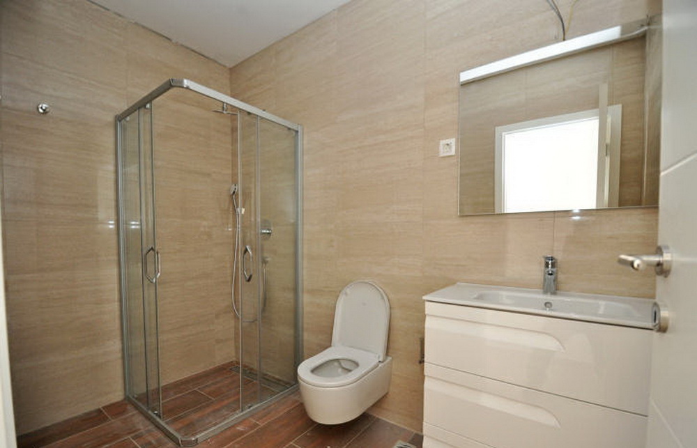 Modern bathroom with a shower cabin and white vanity in a residential complex, Tivat, Montenegro.