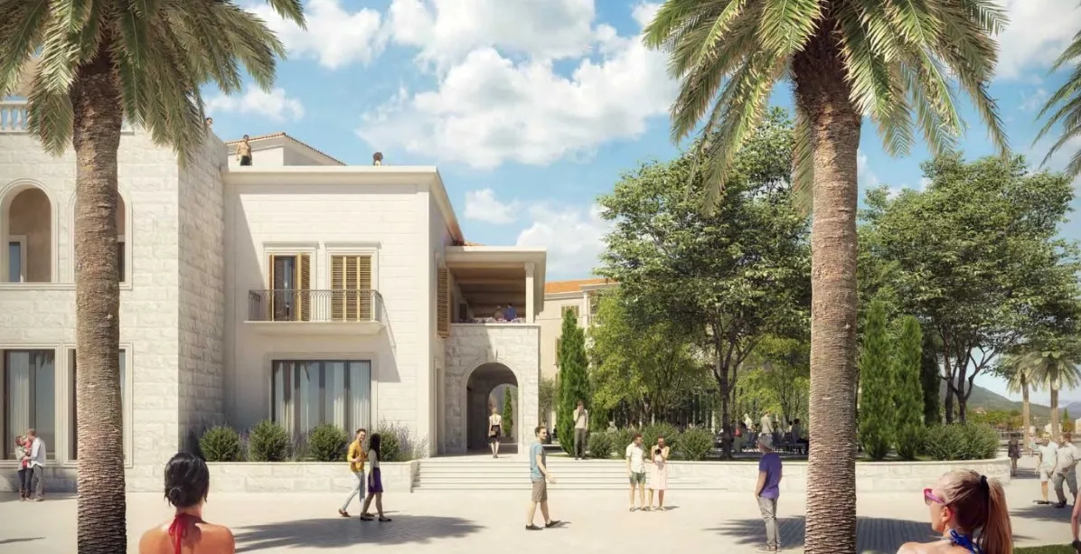 Exterior view of a white building with palm trees and people in a sunny plaza.