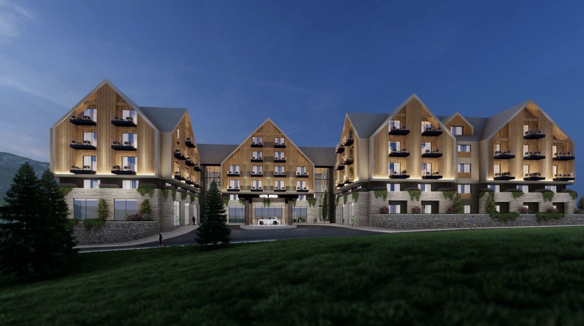 Facade of the Breza Hotel in Kolašin, Montenegro: modern architecture with wood cladding and a stone base at night.