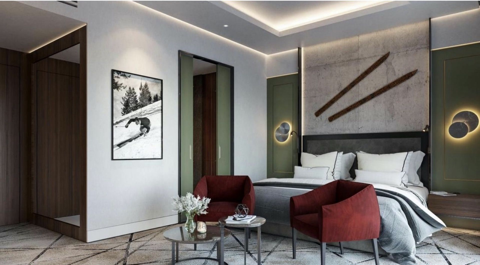 Modern bedroom in a hotel in Kolašin, Montenegro: a double bed, red armchairs, and ski resort-style decor.