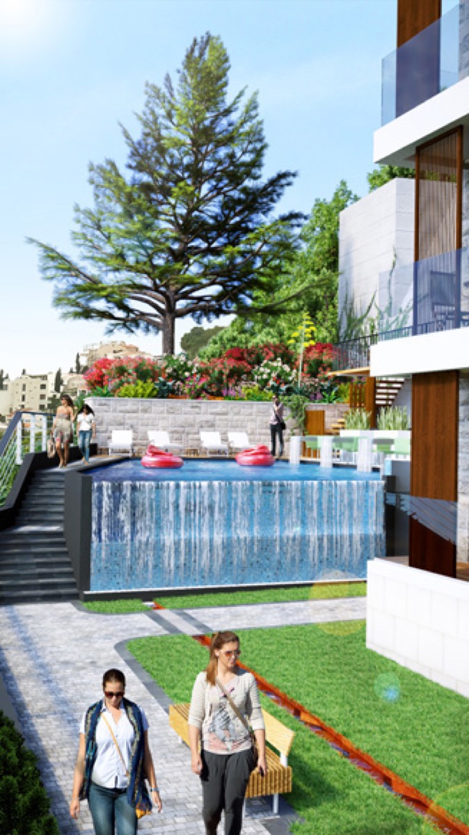 Swimming pool with a waterfall in a residential complex in Budva, Montenegro: landscaped grounds, sun loungers, and landscape design.