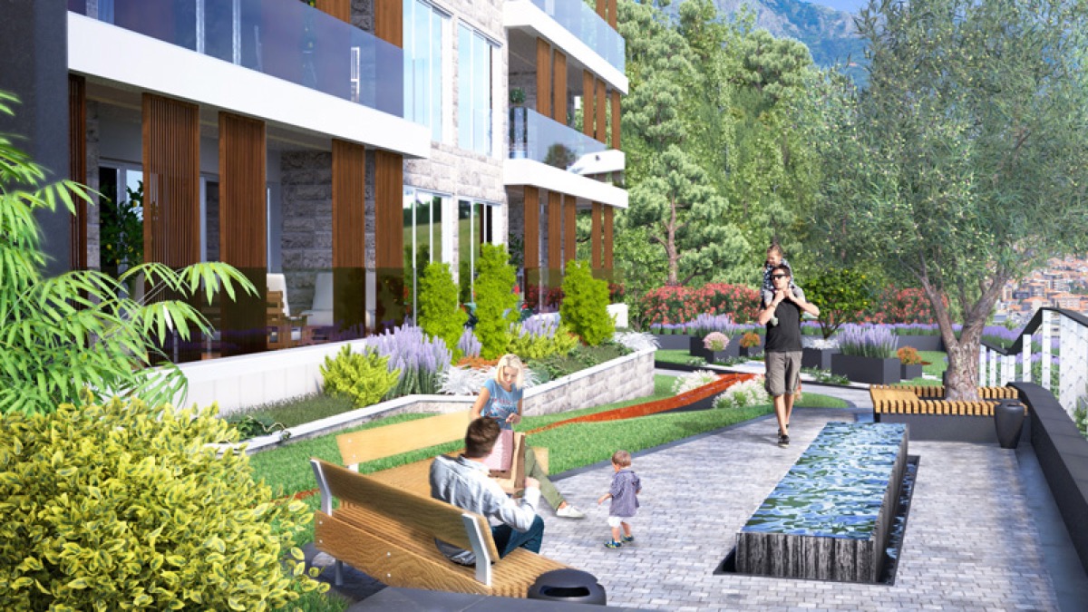 Landscaped grounds of a residential complex in Budva, Montenegro: landscape design, a fountain, and relaxation areas by the building.