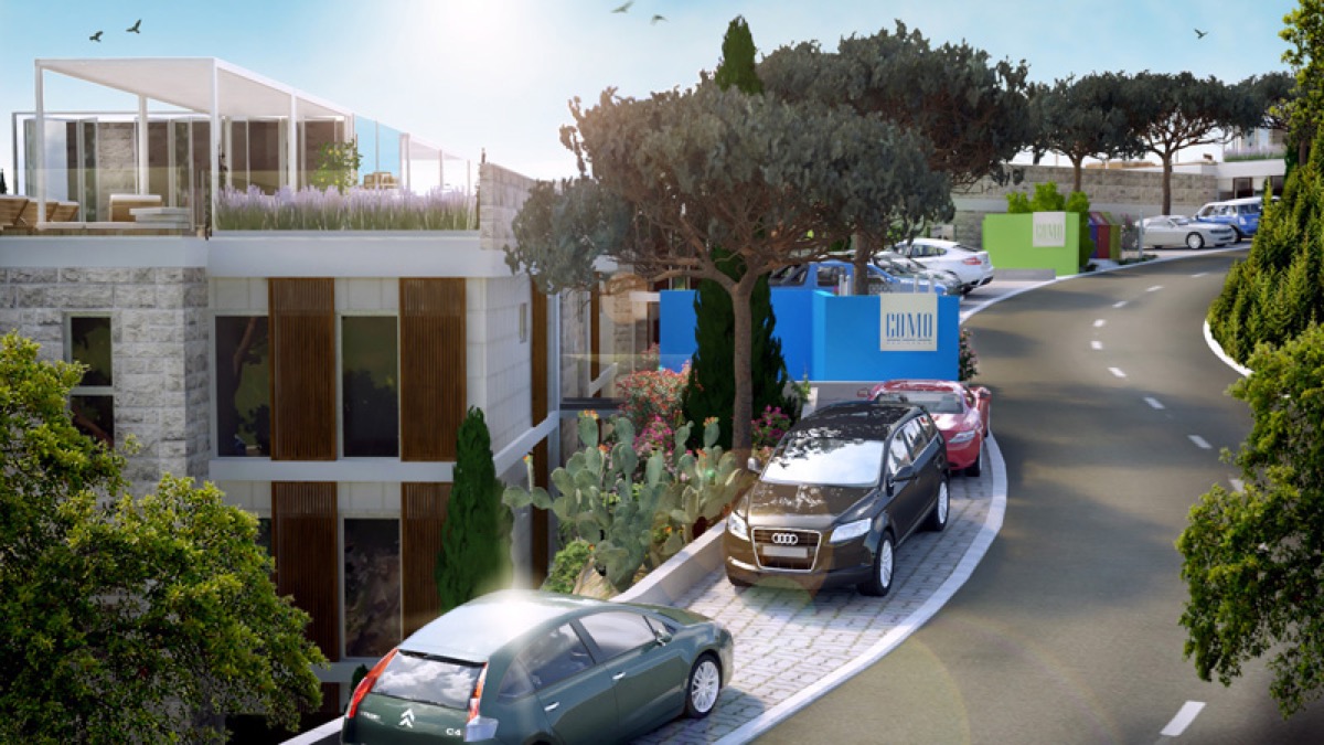 Modern residential complex Como in Budva, Montenegro: view of the building facade, parking area, and landscaped grounds.