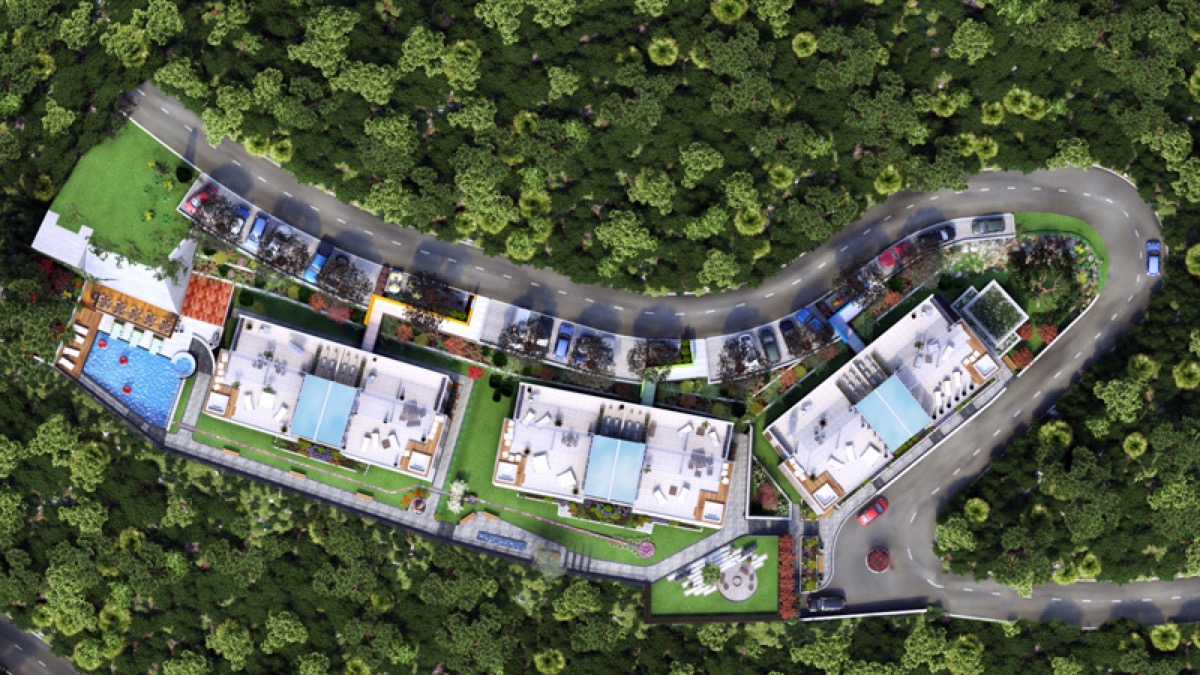 Aerial view of a residential complex in Budva, Montenegro: modern villas with pools, terraces, and parking in a forest.