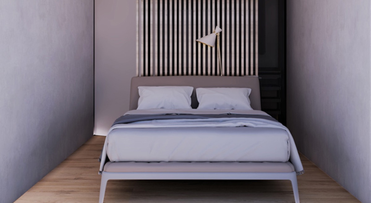 Modern bedroom with a double bed and slatted wall decor in a residential complex, Budva, Montenegro.