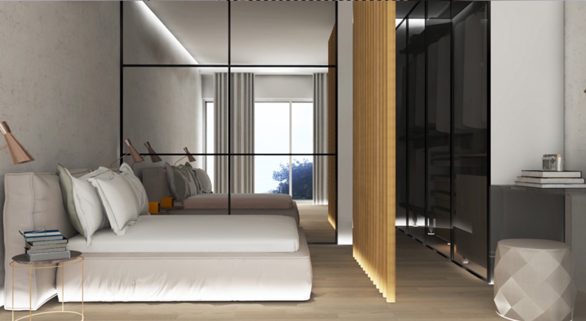 Modern bedroom in the Budva residential complex, Montenegro: double bed, mirrored partition, and walk-in closet with lighting.