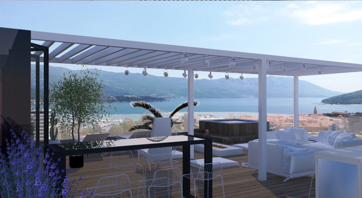 Penthouse terrace in Budva, Montenegro: jacuzzi, lounge area with white furniture, and panoramic sea and mountain views.