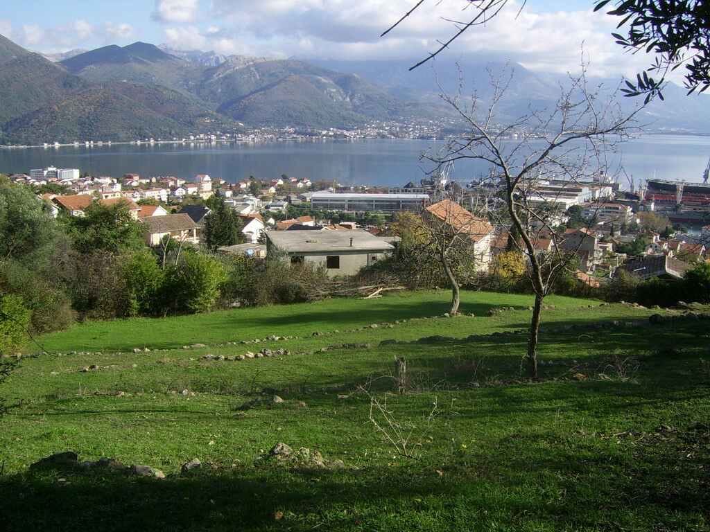 Land plot in Bijela, Montenegro with panoramic views of the sea, mountains, and the coastal cityscape.