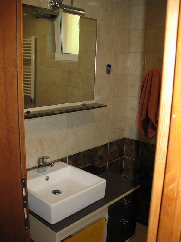 Bathroom in a villa in Shushan, Montenegro: modern sink, mirror, and light-toned tile finishes.